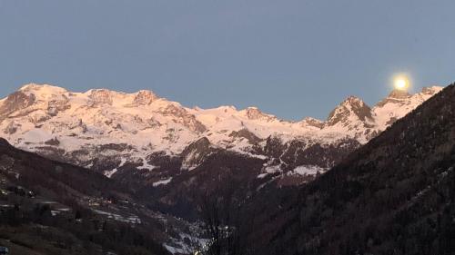 a snow covered mountain with the sun shining on it at Rascard Monterosa in Champoluc