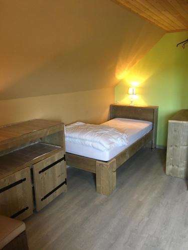 a small bedroom with a bed and a lamp at Vakantiewoning Bij Brugge in Torhout