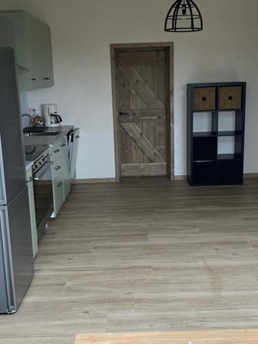 a kitchen with a door and a stove and a refrigerator at Vakantiewoning Bij Brugge in Torhout