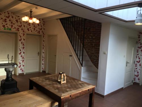 a room with a wooden table and a staircase at Vakantiewoning Bij Brugge in Torhout