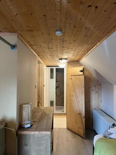 a room with a bed and a wooden ceiling at Vakantiewoning Bij Brugge in Torhout