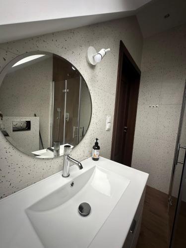 a bathroom with a white sink and a mirror at Pokoje Stajnia Kaliska in Łochów