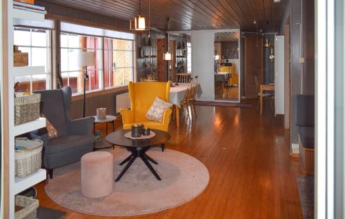 a living room with yellow chairs and a table at Cozy Home In Noresund With Kitchen in Noresund