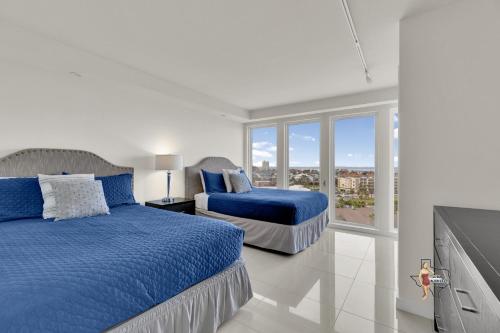 a white bedroom with two beds and a window at Bahia Mar-Solare Tower, Beachfront Resort with Two Pools in South Padre Island