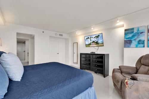 a bedroom with a bed and a couch and a tv at Bahia Mar-Solare Tower, Beachfront Resort with Two Pools in South Padre Island
