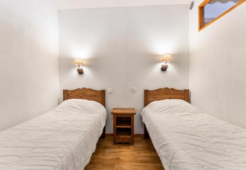 deux lits dans une chambre aux murs blancs dans l'établissement Résidence Les Hauts De Preclaux - Logement pour 6 personnes au coeur des Orres 1800 MAE-5331, aux Orres