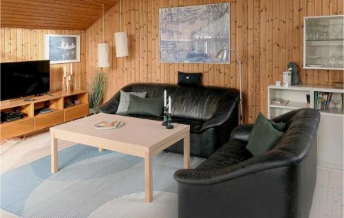 un soggiorno con un divano in pelle e un tavolo di Three-Bedroom Holiday Home In Strandby a Strandby