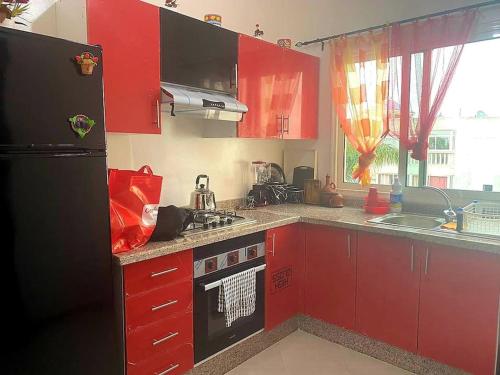 Pont BlondinにあるAppartement, Salam Beachのキッチン(赤いキャビネット、黒い冷蔵庫付)
