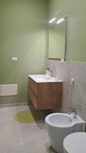 a bathroom with a sink and a toilet and a mirror at Casa La Bisbetica in San Damiano dʼAsti