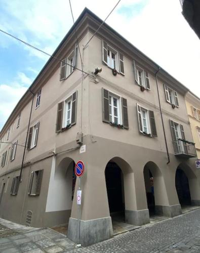 a large building with arches on a street at Casa La Bisbetica in San Damiano dʼAsti