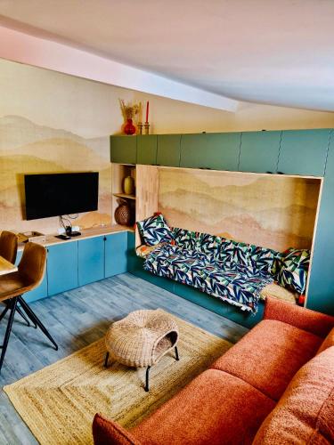 un salon avec un canapé et une télévision dans l'établissement bel studio paris, pantin, à Pantin