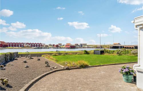 a group of pigeons sitting on a sidewalk near a body of water at Stunning Home In Ulfborg With Wifi in Ulfborg