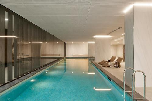 a swimming pool with blue water in a building at Caulfield Apartments by Urban Rest in Melbourne