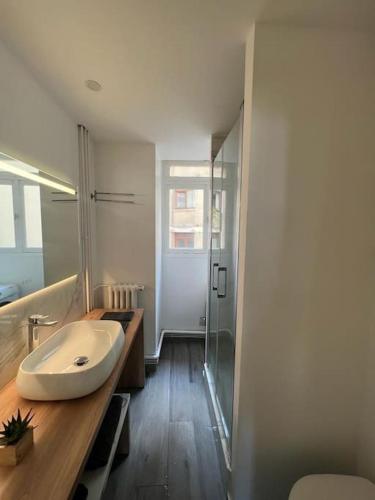 une salle de bain avec un lavabo et une douche en verre dans l'établissement Magnifique appartement Paris 2 chambres Tour Eiffel, à Paris