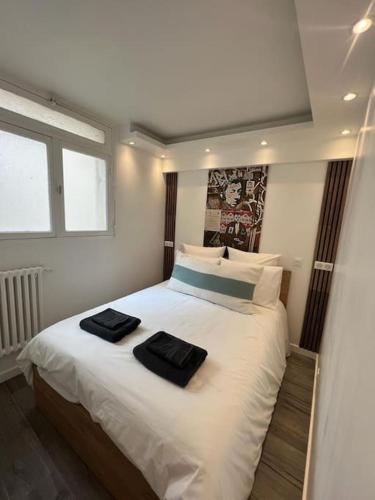 - une chambre avec un lit et 2 serviettes noires dans l'établissement Magnifique appartement Paris 2 chambres Tour Eiffel, à Paris