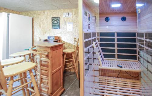 a room with a bar with stools and a refrigerator at Amazing Home In Grenaa With Wifi in Grenå