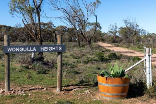 a street sign in a field with a plant at Wongulla Heights in Wongulla
