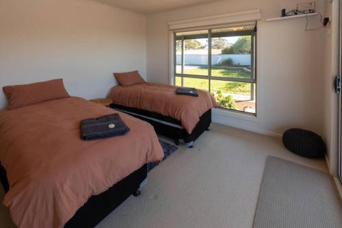 a bedroom with two beds and a window with a view at Wongulla Heights in Wongulla