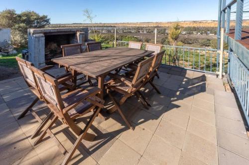 a wooden table and chairs sitting on a patio at Wongulla Heights in Wongulla