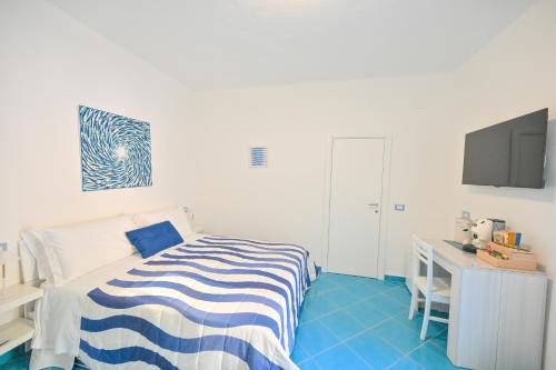 a bedroom with a bed and a desk and a tv at Chiaia Di Rose Rooms & Apartment in Ischia