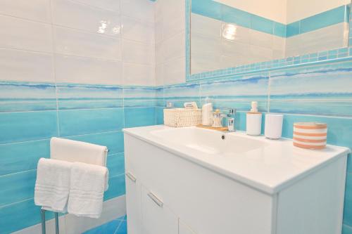 a blue and white bathroom with a sink and a mirror at Chiaia Di Rose Rooms & Apartment in Ischia