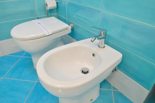 a bathroom with a white toilet and a sink at Chiaia Di Rose Rooms & Apartment in Ischia