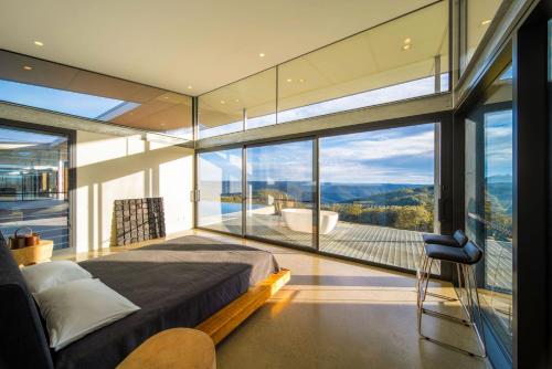 a bedroom with a large window with a view of a tub at Mountain Top Bilpin, Long House Isyd in Bilpin
