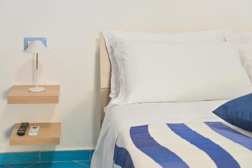 a bedroom with a bed and a night stand with a lamp at Chiaia Di Rose Rooms & Apartment in Ischia