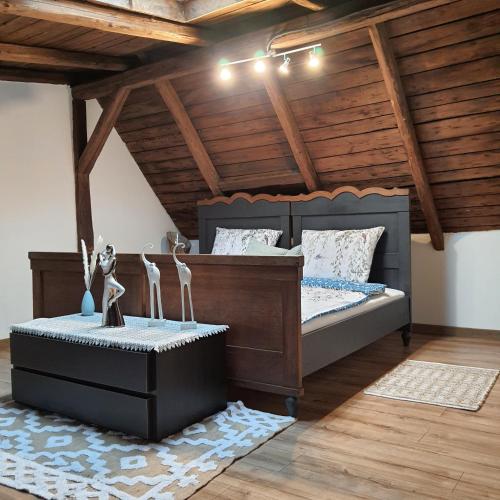 a bedroom with a bed and a wooden ceiling at Apartament wiejska chata 150m2 in Piece