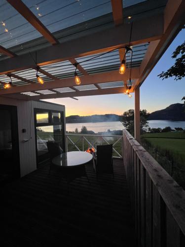 a patio with a table and chairs and a view of the water at Lysefjorden - Gøysa Gard in Forsand