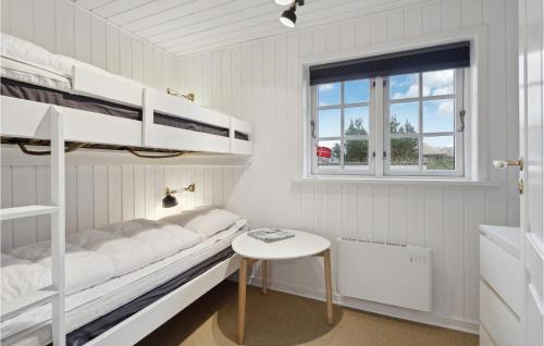 a bedroom with two bunk beds and a table at Lovely Home In Ringkøbing With Wifi in Søndervig