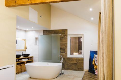 a bathroom with a large white tub in a room at Villa Meyzieu Grand Large in Meyzieu