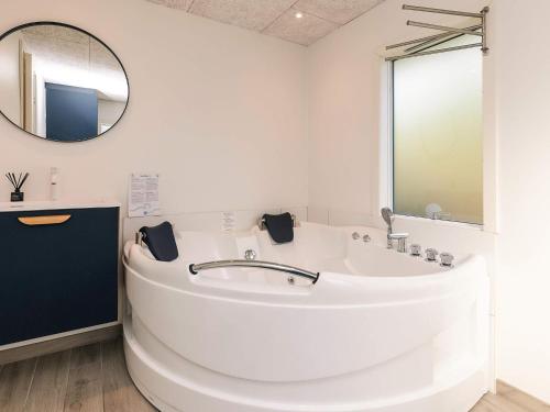 a white bathroom with a large tub and a mirror at 8 person holiday home in Otterup-By Traum in Otterup