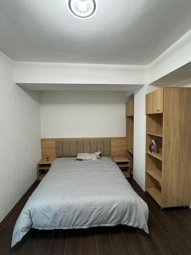 a bedroom with a large bed and wooden cabinets at Cozy apartment with free parking in Prilep