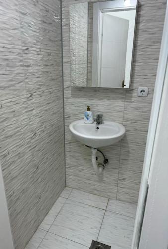a bathroom with a sink and a mirror at Cozy apartment with free parking in Prilep