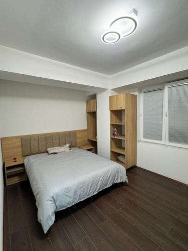 Un dormitorio con una cama grande y una ventana. en Cozy apartment with free parking, en Prilep