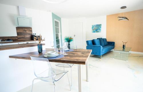 a living room with a table and a blue couch at NUXIA Suites&SPA - L'Art Design in Bagnols-sur-Cèze
