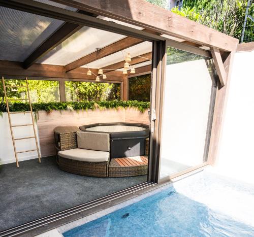 - une terrasse avec un canapé et une piscine dans l'établissement NUXIA Suites&SPA - L'Art Design, à Bagnols-sur-Cèze