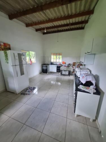 a large room with a kitchen and a refrigerator at Chácara Cantinho dos Sonhos in Chapada dos Guimarães