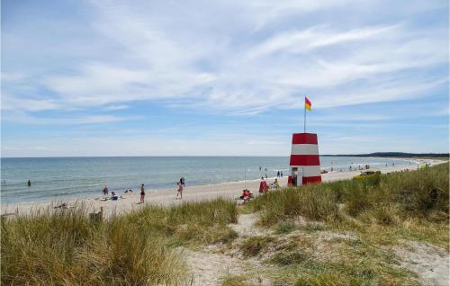 a group of people on a beach with a red and white lighthouse at Holiday Home Katholm in Ålsrode