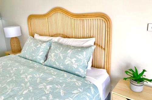 a bedroom with a bed with a wooden headboard at Salty Blue Beach House in Kalbarri