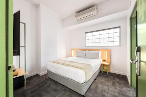 a bedroom with a white bed and a window at YHA Brisbane City in Brisbane