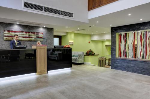 a lobby with a reception desk and a painting of a man at Frensham Pond Country House Hotel & Spa in Farnham