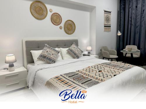 a white bedroom with a large bed with pillows at Bella INN - Deluxe Master rooms with Balcony - No Smoking in Dubai