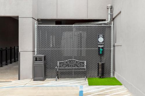 a fence with a bench in front of a building at Red Roof Inn PLUS Jamaica, NY - JFK Airport in Jamaica