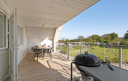 a porch with a grill and a table on a balcony at Beautiful Apartment In Glesborg in Glesborg