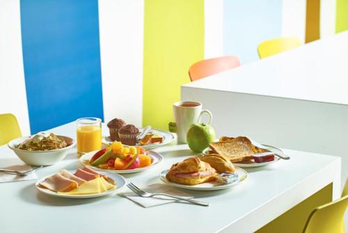 a table topped with plates of breakfast foods and orange juice at ibis budget Birmingham Centre in Birmingham