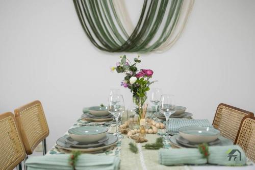 a dining room table with plates and flowers on it at Utopia 2B2B in Wentworth Point&Olympic Park in Sydney