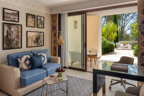 a living room with a blue couch and a table at Fairmont Tazi Palace Tangier in Tangier