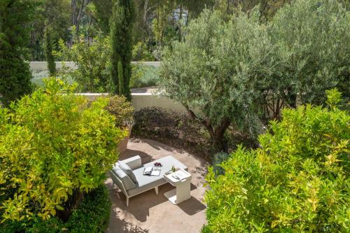 a garden with a bench and a table and trees at Fairmont Tazi Palace Tangier in Tangier